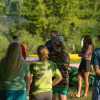 group of adults standing outside in the shade listening to a presenter
